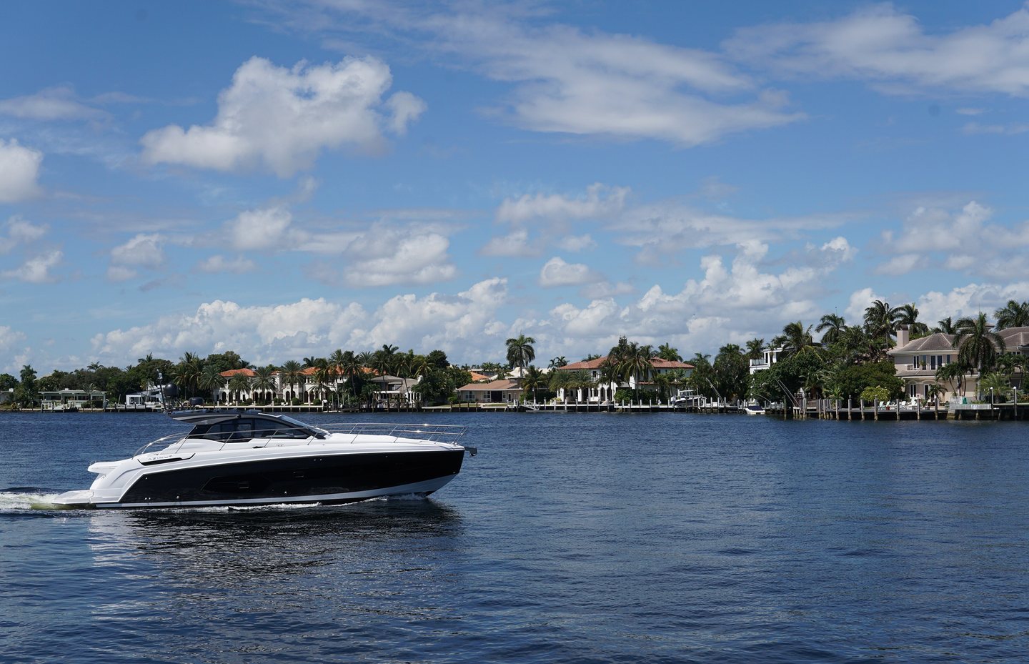 Boat crossing the Intracoastal Waterway in Fort Lauderdale, waterfront houses along the shore
